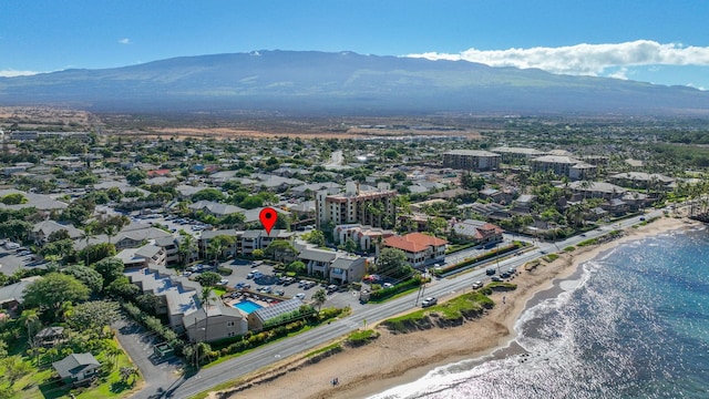 drone / aerial view featuring a water and mountain view and a beach view