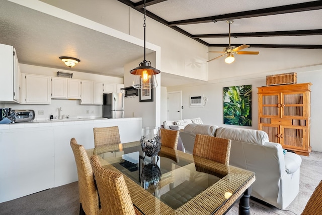 carpeted dining area with sink, vaulted ceiling with beams, ceiling fan, a textured ceiling, and a wall unit AC