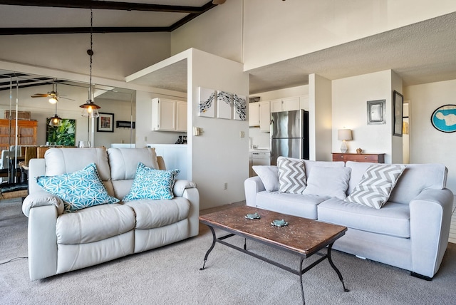 living room with ceiling fan, beamed ceiling, high vaulted ceiling, light colored carpet, and a textured ceiling