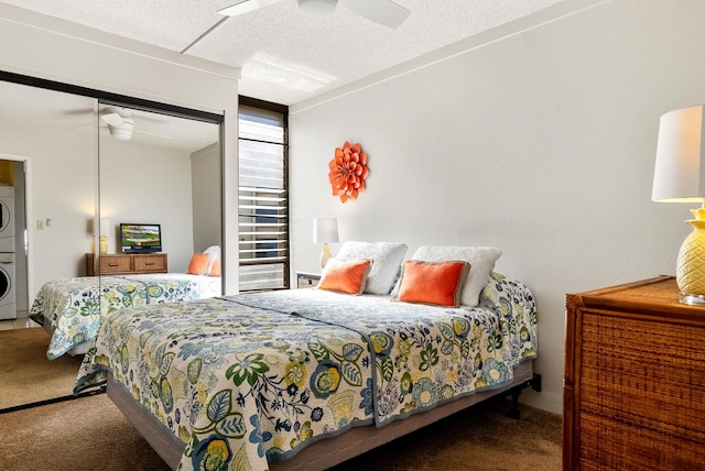 bedroom featuring carpet, a closet, stacked washing maching and dryer, and ceiling fan