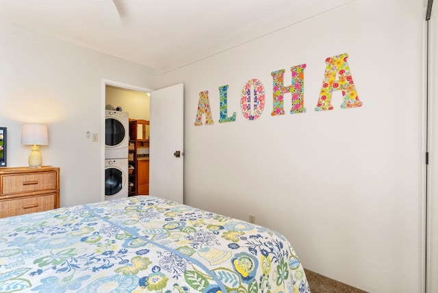 carpeted bedroom featuring ceiling fan and stacked washer and clothes dryer