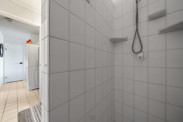 bathroom with a tile shower and tile patterned floors