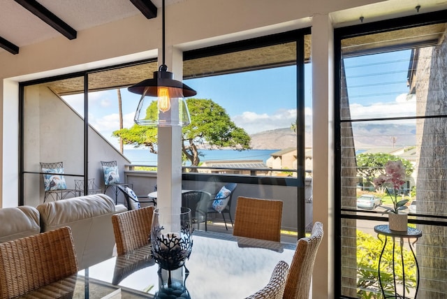 dining room featuring beamed ceiling and plenty of natural light