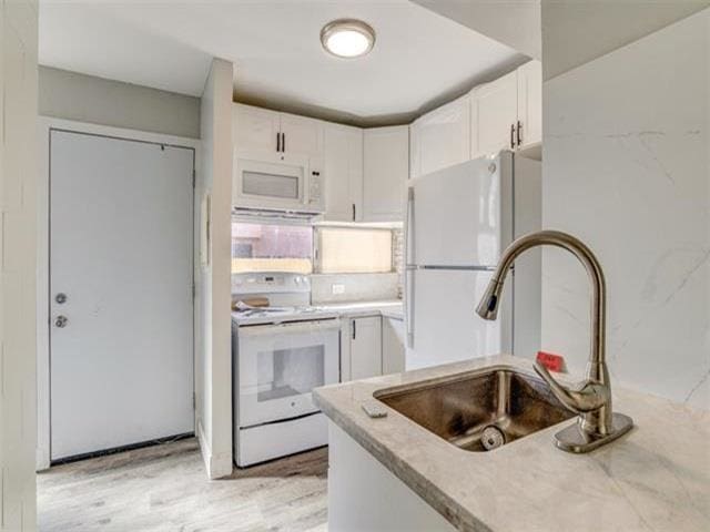 3676 Lower Honoapiilani Rd Unit F303, Lahaina, HI 96761 - kitchen featuring white cabinetry, white appliances, sink, and light hardwood / wood-style flooring