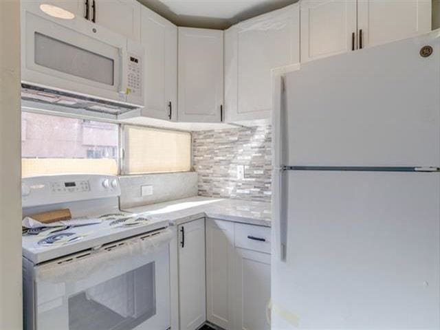 3676 Lower Honoapiilani Rd Unit F303, Lahaina, HI 96761 - kitchen featuring decorative backsplash, white cabinetry, and white appliances