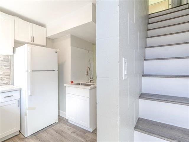 3676 Lower Honoapiilani Rd Unit F303, Lahaina, HI 96761 - kitchen featuring white cabinets, white refrigerator, light wood-type flooring, and sink
