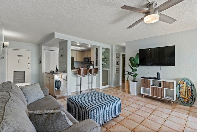 tiled living room featuring ceiling fan and a textured ceiling