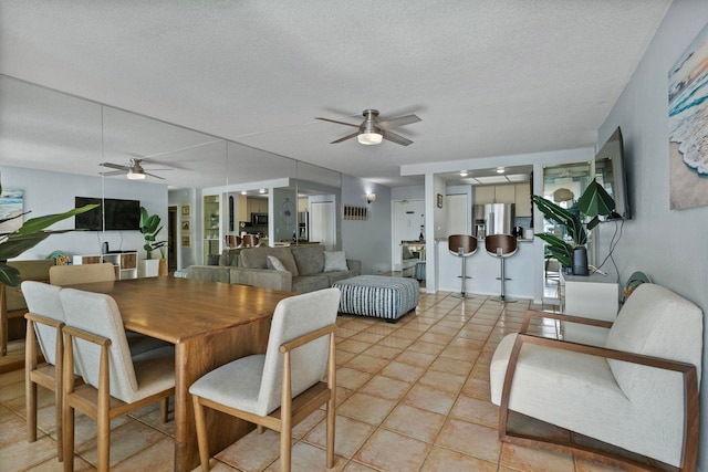 dining area featuring light tile patterned flooring, ceiling fan, and a textured ceiling