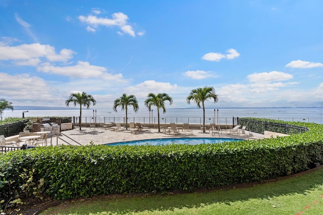 view of pool featuring a water view and a patio