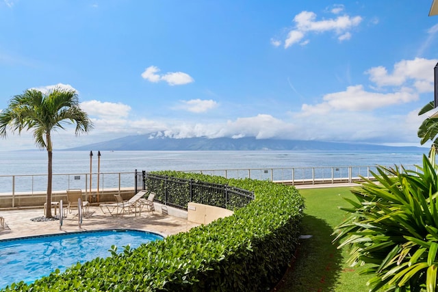 view of pool with a patio and a water and mountain view