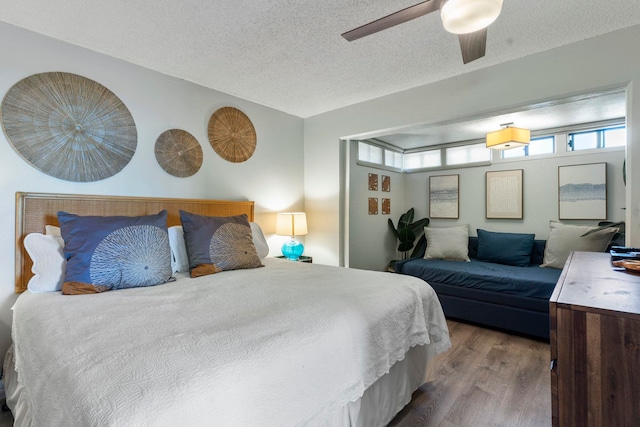 bedroom featuring wood-type flooring, a textured ceiling, and ceiling fan