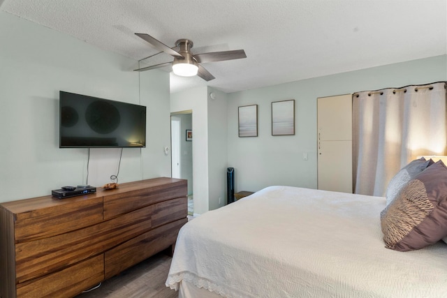 bedroom with wood-type flooring, a textured ceiling, and ceiling fan