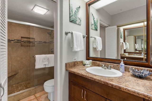 bathroom with vanity, tile patterned flooring, toilet, and an enclosed shower