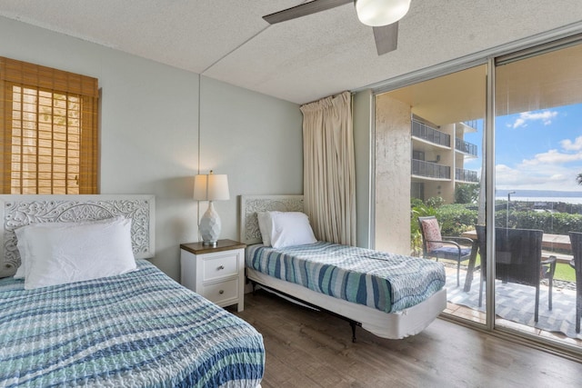 bedroom with access to outside, dark hardwood / wood-style floors, a textured ceiling, and ceiling fan