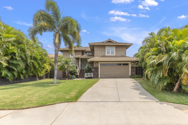 view of front of house with a garage, a front yard, and driveway