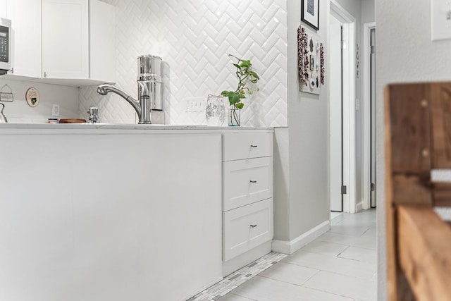 bathroom featuring tile patterned floors, decorative backsplash, and baseboards