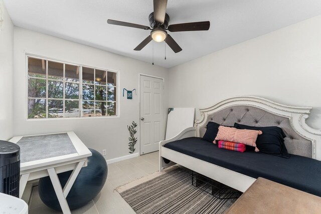 bedroom featuring light tile patterned floors, baseboards, and a ceiling fan