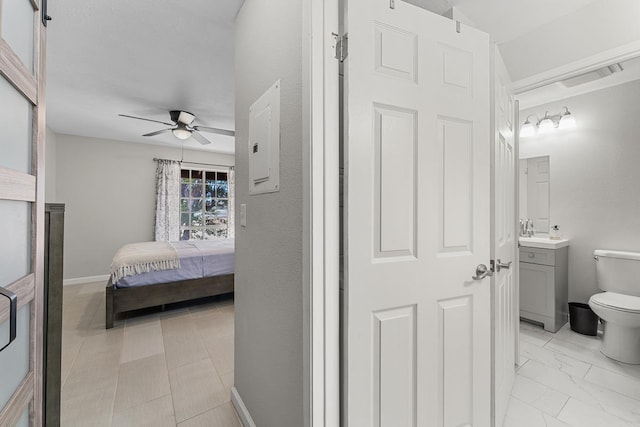 ensuite bathroom featuring toilet, ensuite bathroom, baseboards, ceiling fan, and vanity