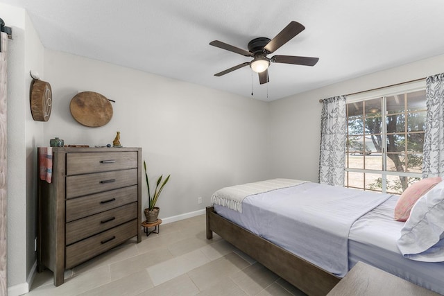 bedroom with light tile patterned flooring, a ceiling fan, and baseboards