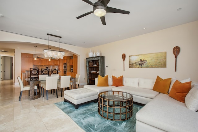 living room with ceiling fan with notable chandelier