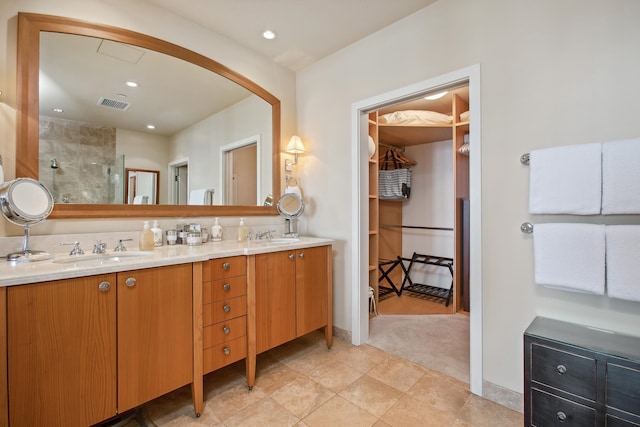 bathroom featuring tile patterned flooring, vanity, and a shower