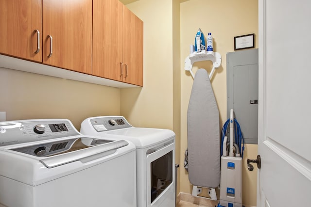 clothes washing area with cabinets and washing machine and clothes dryer