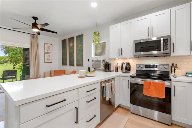 4435 Lower Honoapiilani Rd Unit 142, Lahaina, HI 96761 - kitchen featuring appliances with stainless steel finishes, a peninsula, decorative backsplash, light countertops, and a ceiling fan