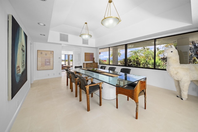 dining space with a raised ceiling and baseboards