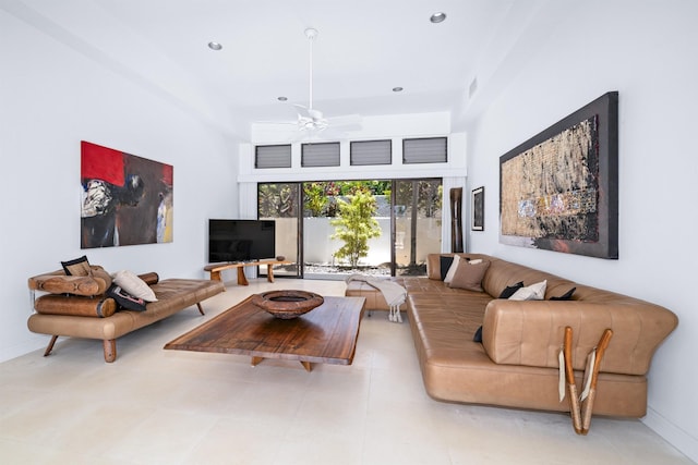 living area with a ceiling fan, recessed lighting, baseboards, and a high ceiling