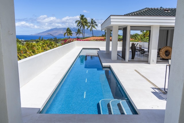 swimming pool with a patio area and a mountain view