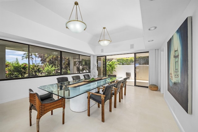 dining room with a tray ceiling, baseboards, and recessed lighting