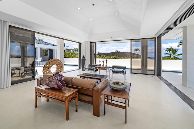 living room featuring vaulted ceiling, recessed lighting, and a tray ceiling