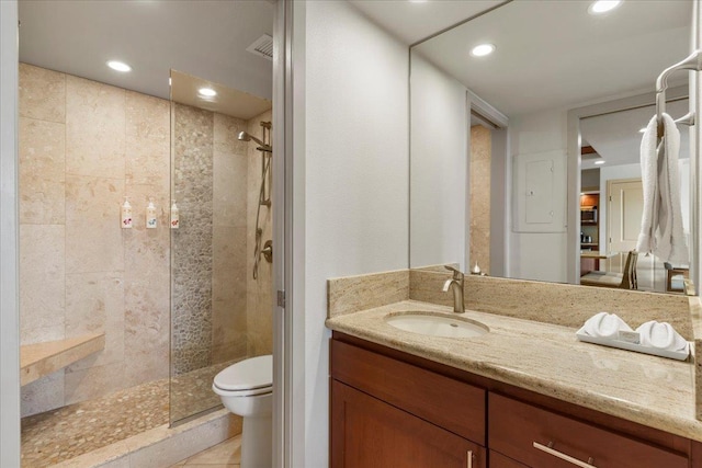 bathroom featuring tile patterned floors, toilet, a tile shower, and vanity