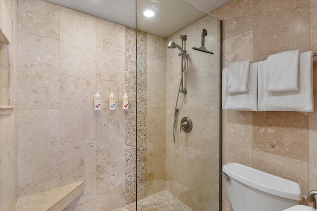 bathroom featuring a tile shower and toilet