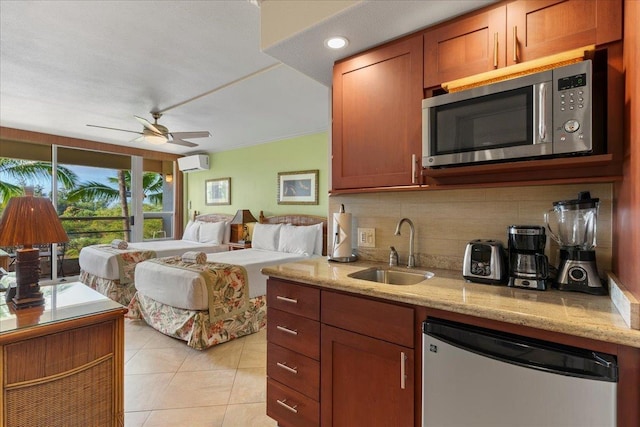 kitchen featuring a wall mounted AC, sink, ceiling fan, appliances with stainless steel finishes, and tasteful backsplash