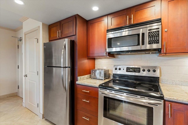 kitchen with backsplash, crown molding, light stone countertops, and stainless steel appliances