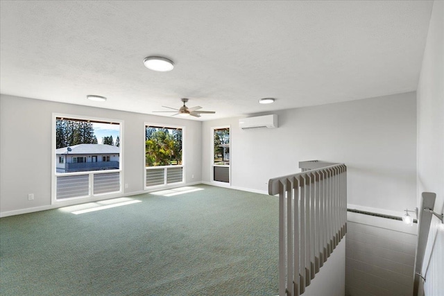 185 Hololani St, Pukalani, HI 96768 - spare room featuring a wall mounted AC, ceiling fan, healthy amount of natural light, dark colored carpet, and a textured ceiling