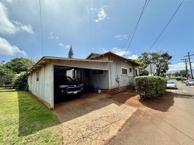 view of home's exterior featuring a yard and a carport