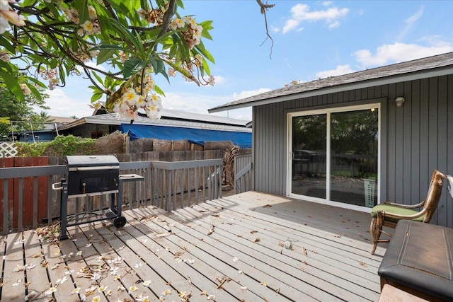 wooden terrace with a fenced backyard
