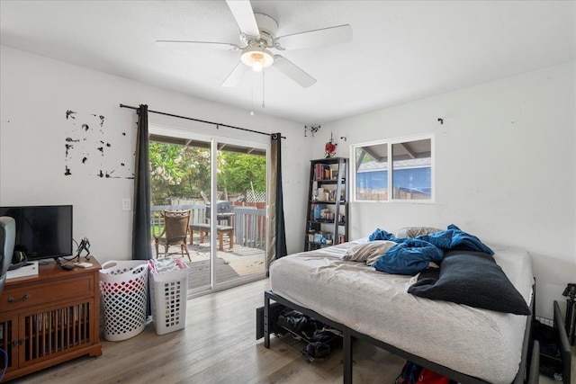 bedroom with ceiling fan, access to outside, and wood finished floors