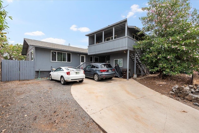 view of front of property with fence, driveway, and stairs