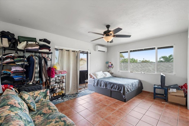 tiled bedroom with ceiling fan and a wall mounted air conditioner