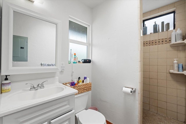 full bath with toilet, tiled shower, a healthy amount of sunlight, and electric panel