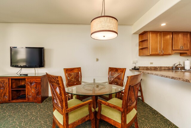 dining space featuring sink and dark carpet