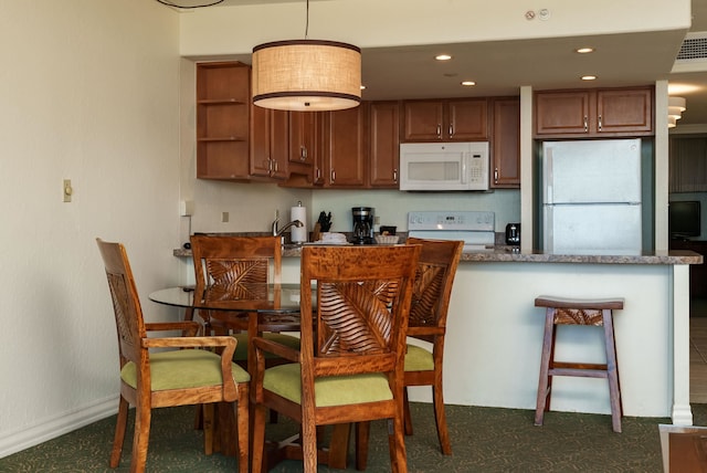 kitchen featuring white appliances and hanging light fixtures