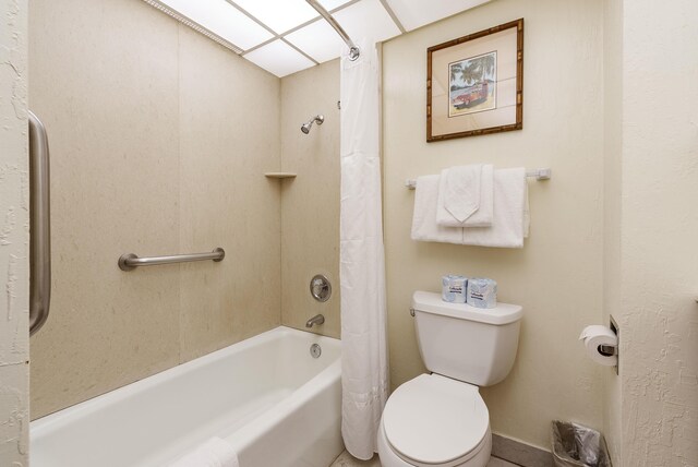 bathroom with shower / bath combination with curtain and toilet