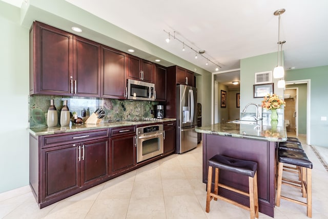 50 Nohea Kai Dr Unit 2-1106, Lahaina, HI 96761 - kitchen with stainless steel appliances, a sink, reddish brown cabinets, backsplash, and a kitchen breakfast bar