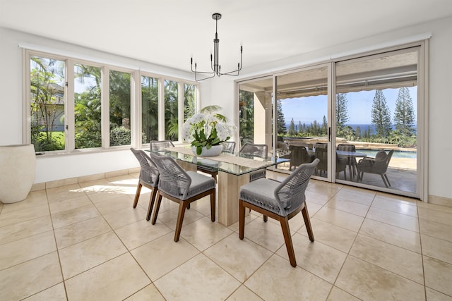 dining area with a wealth of natural light, baseboards, an inviting chandelier, and light tile patterned floors