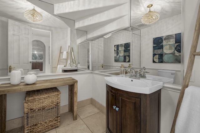 bathroom with an inviting chandelier, tile patterned flooring, and vanity