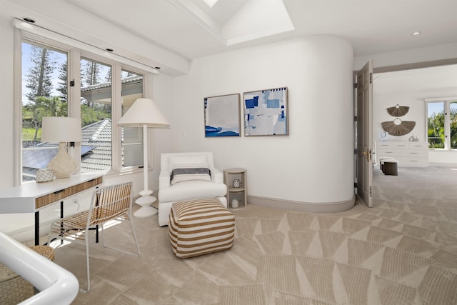 sitting room featuring light carpet and baseboards